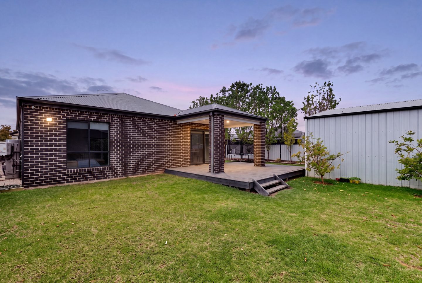 Rear garden and deck at dusk