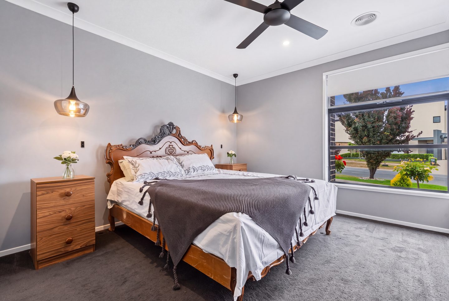 Main bedroom with ceiling fan and pendant lights